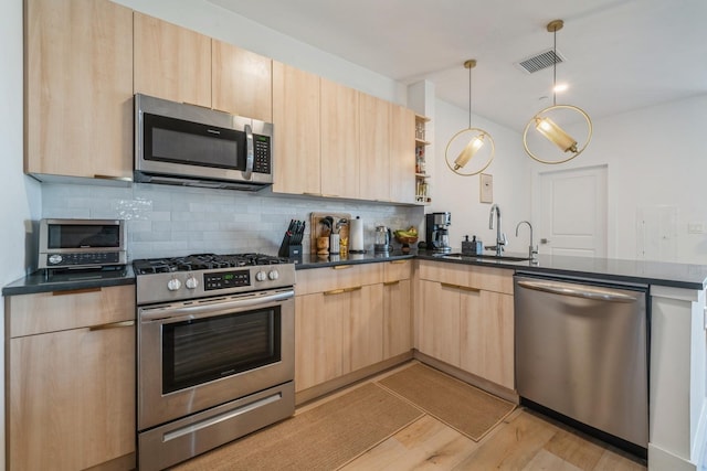 kitchen featuring a sink, modern cabinets, light brown cabinets, and stainless steel appliances