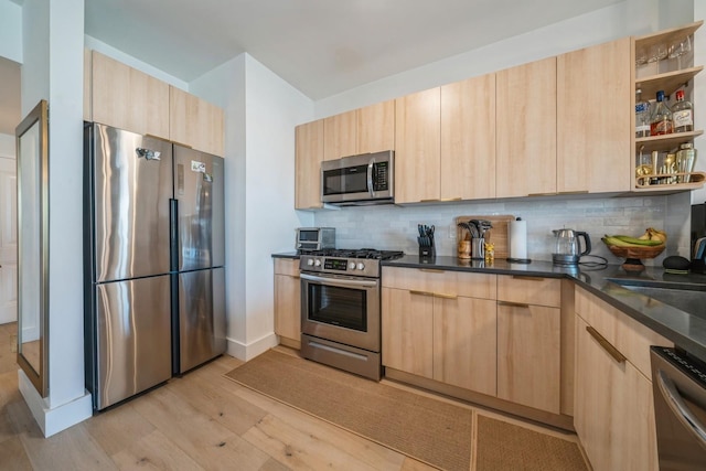 kitchen with modern cabinets, stainless steel appliances, decorative backsplash, and light brown cabinets