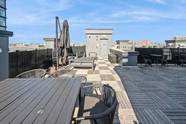 wooden terrace with a view of city and outdoor dining area