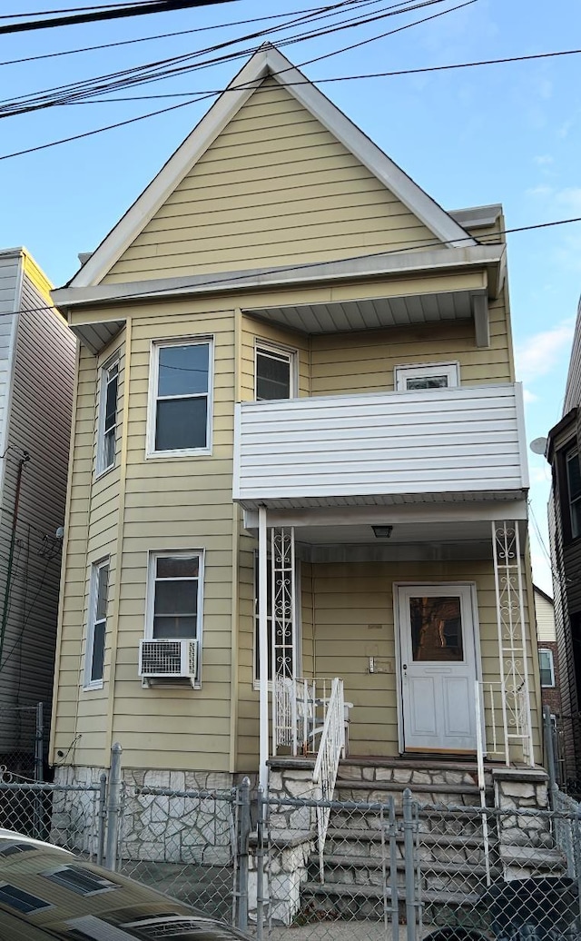 view of front of home with a balcony, cooling unit, and a porch