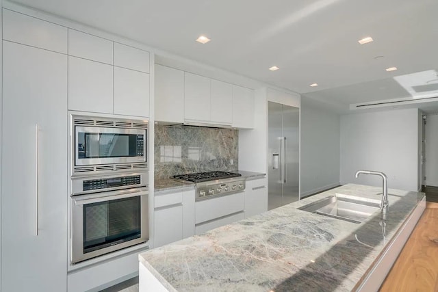 320 Adolphus Ave Unit 1415, Cliffside Park, NJ 07010 - kitchen featuring built in appliances, a sink, modern cabinets, and white cabinets