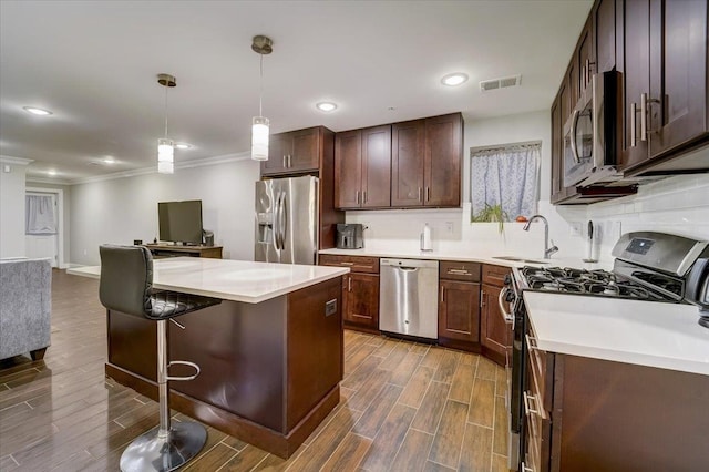2765 Kennedy Blvd Unit 1, Jersey City, NJ 07306 - kitchen featuring appliances with stainless steel finishes, wood finish floors, crown molding, a kitchen island, and hanging light fixtures