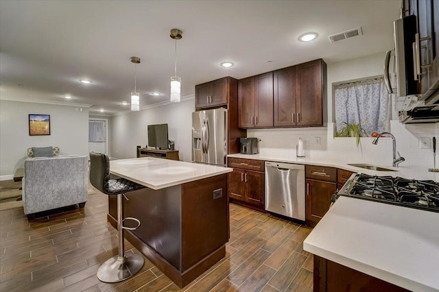 2765 Kennedy Blvd Unit 1, Jersey City, NJ 07306 - kitchen featuring appliances with stainless steel finishes, dark wood-style flooring, a center island, tasteful backsplash, and light countertops