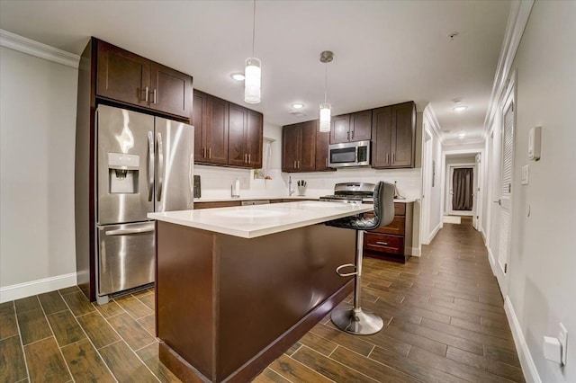 2765 Kennedy Blvd Unit 1, Jersey City, NJ 07306 - kitchen featuring appliances with stainless steel finishes, wood finish floors, dark brown cabinetry, crown molding, and a kitchen island