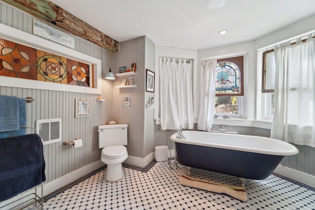 bathroom with a washtub and toilet