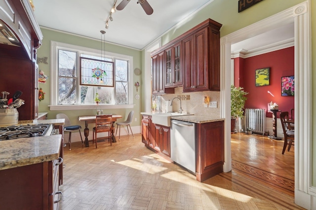 kitchen with sink, crown molding, hanging light fixtures, stainless steel dishwasher, and radiator