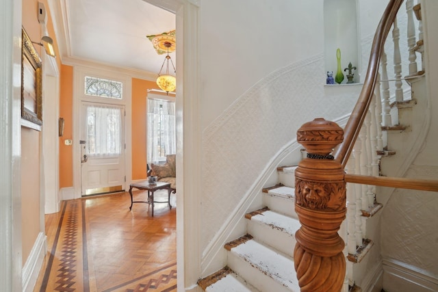 entrance foyer featuring parquet floors and ornamental molding