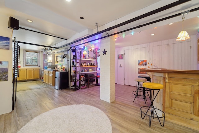 kitchen with fridge, light hardwood / wood-style floors, and hanging light fixtures