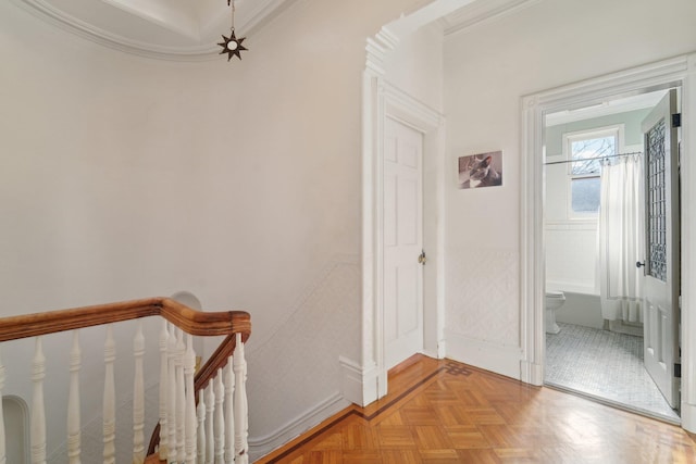 hallway with ornamental molding and light parquet floors