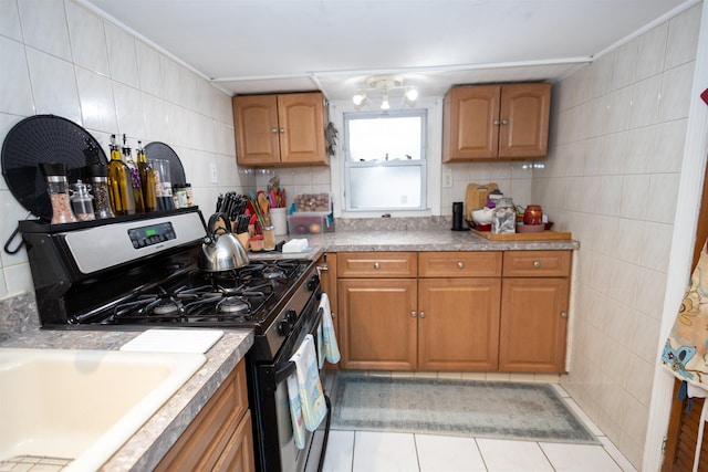 9005 Durham Ave, North Bergen, NJ 07047 - kitchen featuring stainless steel range with gas stovetop, light tile patterned floors, brown cabinets, decorative backsplash, and tile walls