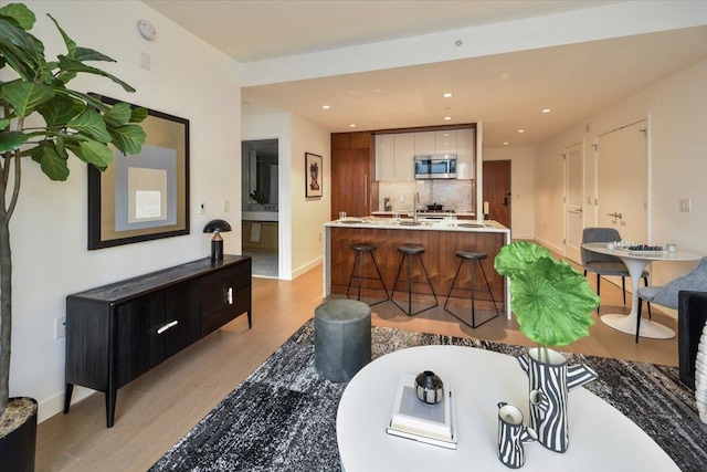 living room with light hardwood / wood-style floors and sink