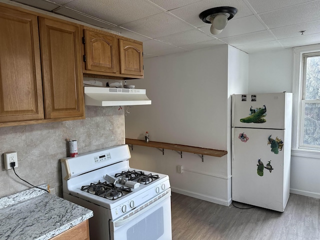 2512 Central Ave, Union City, NJ 08070 - kitchen featuring white appliances, under cabinet range hood, a drop ceiling, light countertops, and light wood-type flooring