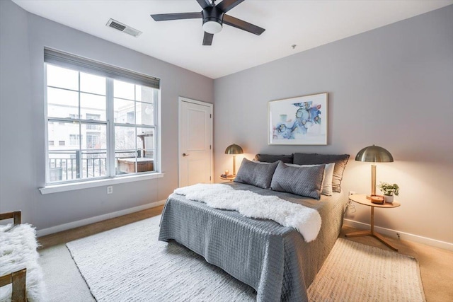 carpeted bedroom with a ceiling fan, visible vents, and baseboards