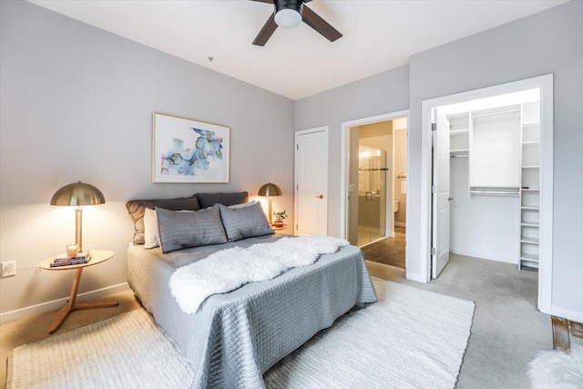 bedroom featuring light carpet, a walk in closet, a ceiling fan, and baseboards