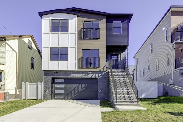 view of front of house featuring fence, stairway, concrete driveway, a front yard, and an attached garage