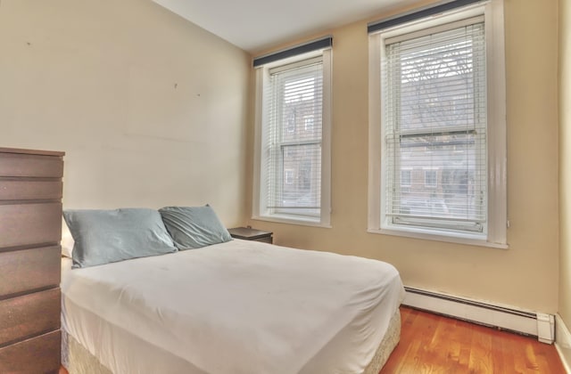 bedroom featuring light hardwood / wood-style floors and baseboard heating