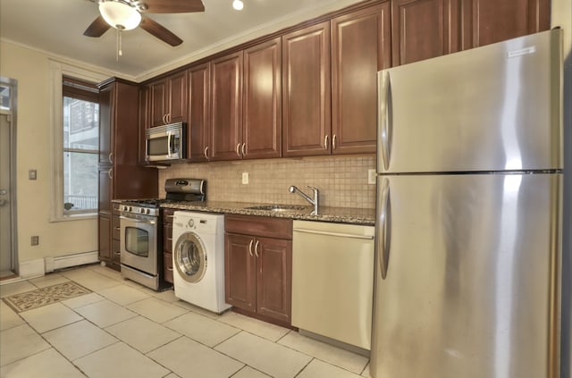 kitchen with appliances with stainless steel finishes, a baseboard heating unit, stone countertops, washer / clothes dryer, and decorative backsplash