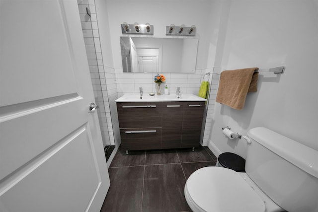 bathroom featuring vanity, tile walls, and toilet