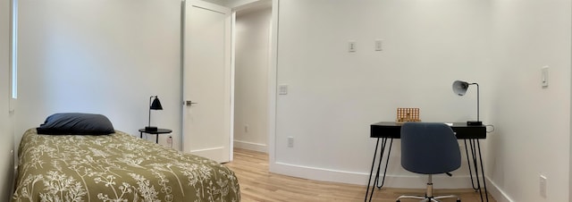 bedroom with light wood-style flooring and baseboards