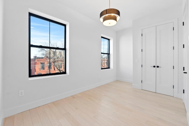 unfurnished bedroom with light wood-type flooring and a closet