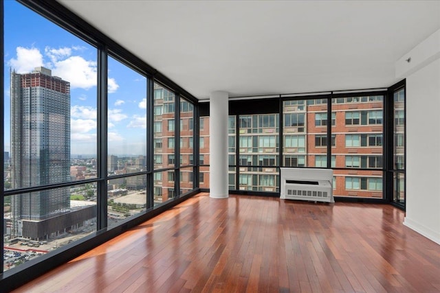 389 Washington St Unit 34E, Jersey City, NJ 07302 - empty room featuring floor to ceiling windows, hardwood / wood-style flooring, a view of city, and plenty of natural light