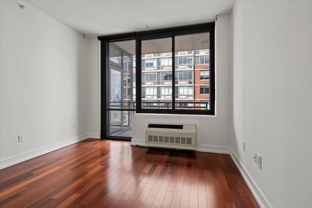 389 Washington St Unit 34E, Jersey City, NJ 07302 - spare room with dark wood-style floors and radiator heating unit