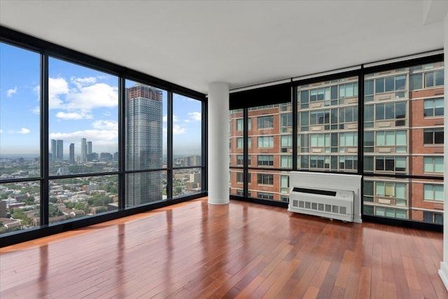 389 Washington St Unit 34E, Jersey City, NJ 07302 - unfurnished room featuring floor to ceiling windows, hardwood / wood-style flooring, and a view of city