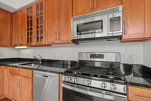 389 Washington St Unit 34E, Jersey City, NJ 07302 - kitchen featuring stainless steel appliances, glass insert cabinets, dark stone countertops, and brown cabinets