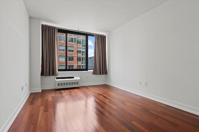 389 Washington St Unit 34E, Jersey City, NJ 07302 - empty room featuring radiator heating unit and hardwood / wood-style flooring