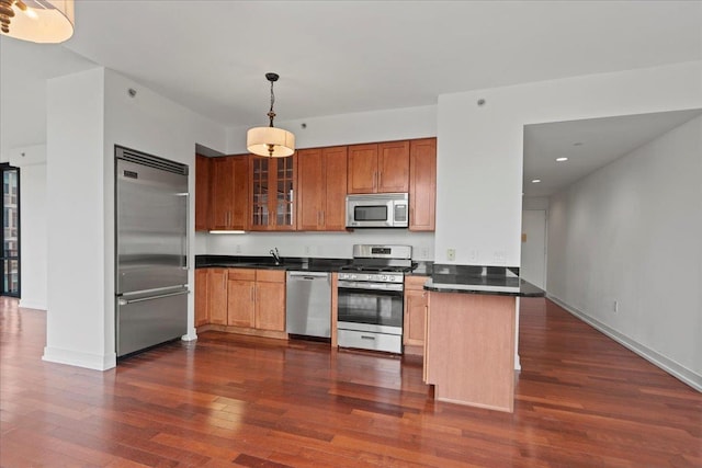 389 Washington St Unit 34E, Jersey City, NJ 07302 - kitchen featuring stainless steel appliances, dark countertops, a peninsula, dark wood-style floors, and glass insert cabinets