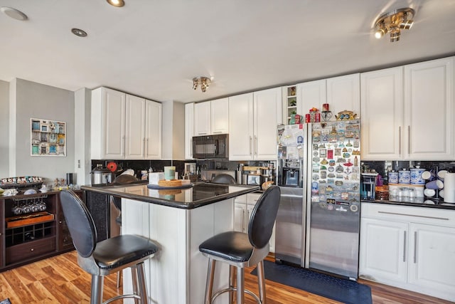 kitchen featuring white cabinets, a kitchen bar, and stainless steel fridge with ice dispenser