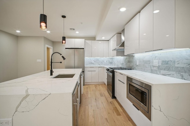 211 Summit Ave Unit 1, Jersey City, NJ 07304 - kitchen featuring white cabinets, light wood-style flooring, a sink, modern cabinets, and appliances with stainless steel finishes