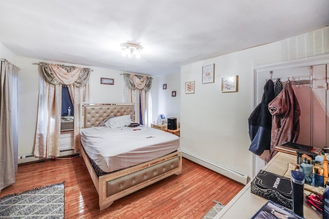 bedroom with wood-type flooring and a baseboard radiator