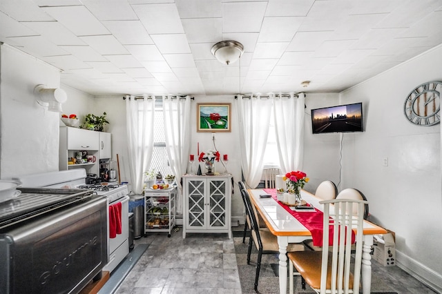 kitchen featuring range with gas stovetop and baseboards