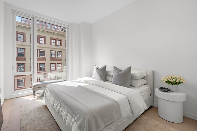 bedroom with baseboards and wood finished floors