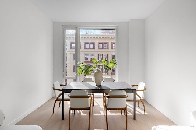 dining space with baseboards and light wood-style floors