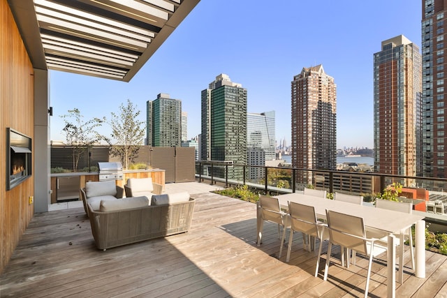 wooden deck featuring grilling area, outdoor dining space, a city view, and area for grilling