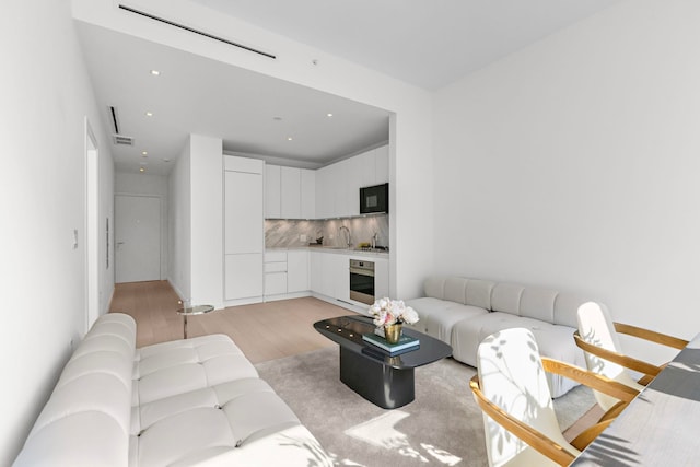 living area with light wood finished floors and visible vents