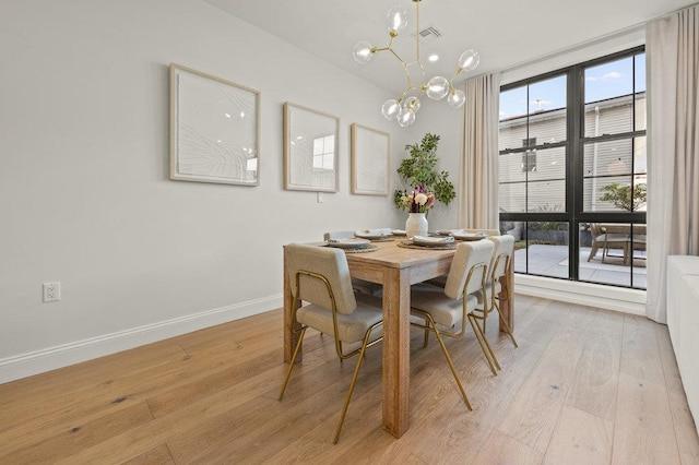 dining room with floor to ceiling windows, light hardwood / wood-style flooring, and a notable chandelier