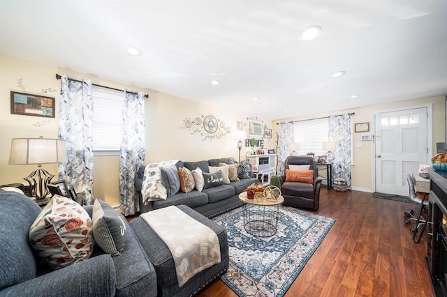 living area featuring an AC wall unit, recessed lighting, wood finished floors, and baseboards