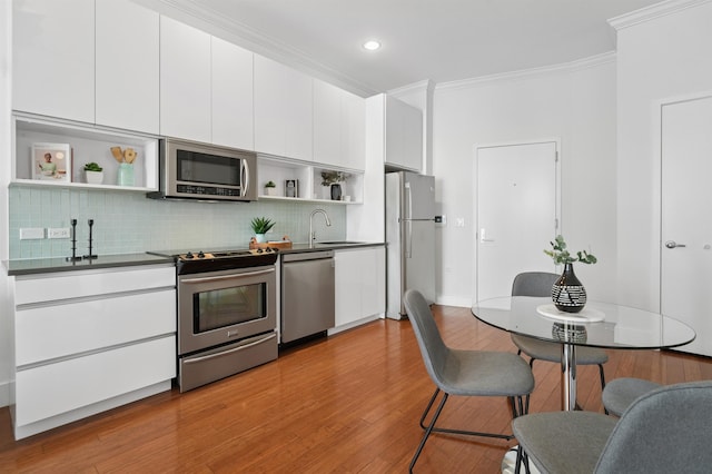 217 Newark Ave Unit 210, Jersey City, NJ 07302 - kitchen with stainless steel appliances, open shelves, crown molding, dark countertops, and decorative backsplash