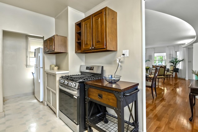83 W 38th St, Bayonne, NJ 07002 - kitchen featuring stainless steel gas range oven, freestanding refrigerator, brown cabinetry, and open shelves