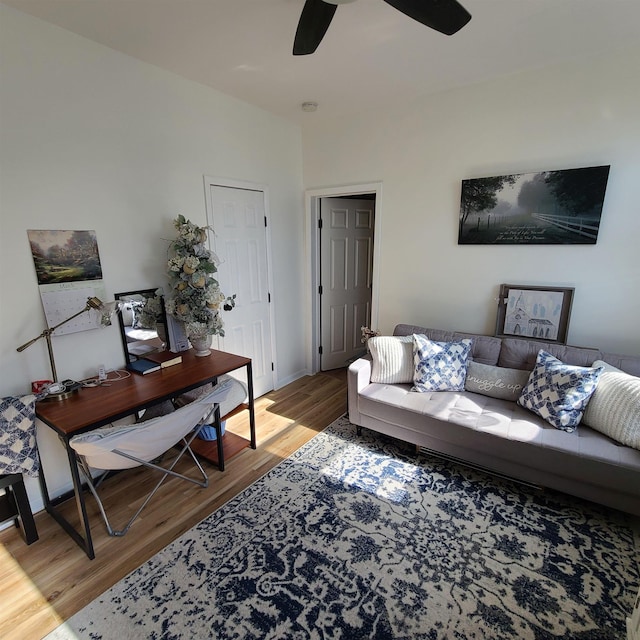 living area with ceiling fan, baseboards, and wood finished floors