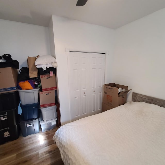 bedroom with dark wood-type flooring, a closet, and a ceiling fan