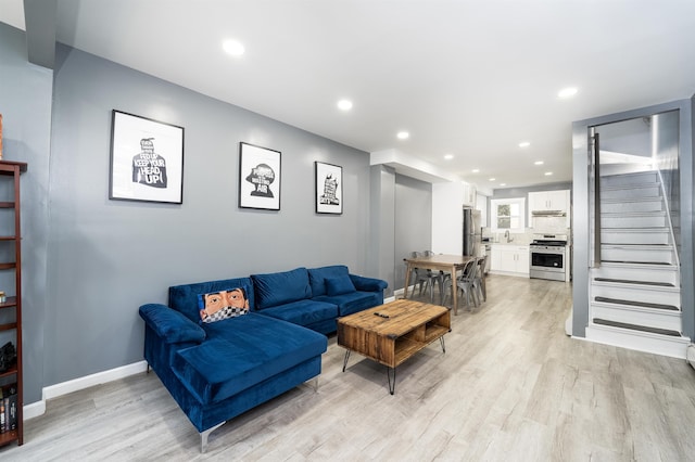 living room featuring sink and light hardwood / wood-style floors