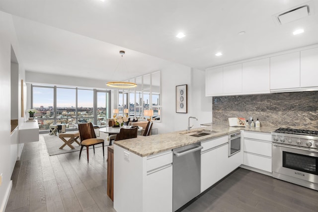 320 Adolphus Ave Unit 907, Cliffside Park, NJ 07010 - kitchen with appliances with stainless steel finishes, a peninsula, dark wood-style floors, decorative backsplash, and recessed lighting
