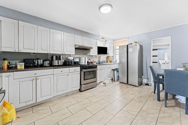 6113 Washington St, West New York, NJ 07093 - kitchen featuring appliances with stainless steel finishes, white cabinetry, under cabinet range hood, tasteful backsplash, and dark countertops