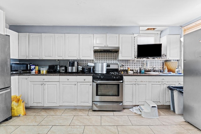 6113 Washington St, West New York, NJ 07093 - kitchen with stainless steel appliances, under cabinet range hood, white cabinetry, and light tile patterned flooring