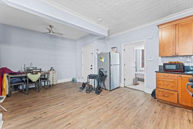 6113 Washington St, West New York, NJ 07093 - kitchen featuring freestanding refrigerator, black microwave, light wood finished floors, ornamental molding, and brown cabinets