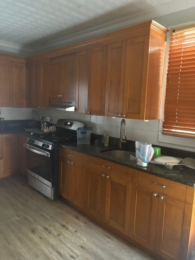 6113 Washington St, West New York, NJ 07093 - kitchen featuring stainless steel electric range oven, under cabinet range hood, brown cabinets, and light wood-style flooring